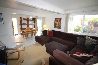 a living room with a brown couch and a table at Mission Beach Bayside Beachy Duplex Flat- 2br 1ba- Sleeps 6 Steps to Beach Bay and Belmont Park in San Diego