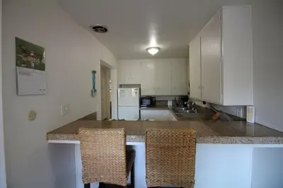 a kitchen with a counter and two chairs in it at Mission Beach Bayside Beachy Duplex Flat- 2br 1ba- Sleeps 6 Steps to Beach Bay and Belmont Park in San Diego