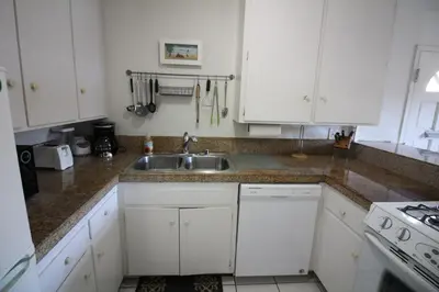 a kitchen with white cabinets and a sink at Mission Beach Bayside Beachy Duplex Flat- 2br 1ba- Sleeps 6 Steps to Beach Bay and Belmont Park in San Diego