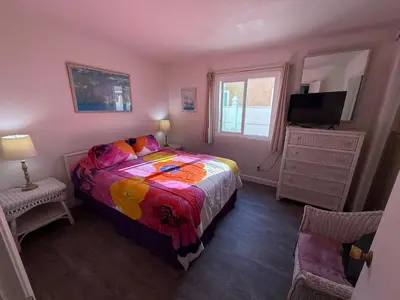 a bedroom with a bed and a television in it at Mission Beach Bayside Beachy Duplex Flat- 2br 1ba- Sleeps 6 Steps to Beach Bay and Belmont Park in San Diego