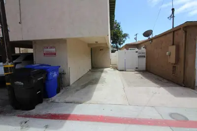 an empty parking lot with two trash cans next to a building at Mission Beach Bayside Beachy Duplex Flat- 2br 1ba- Sleeps 6 Steps to Beach Bay and Belmont Park in San Diego