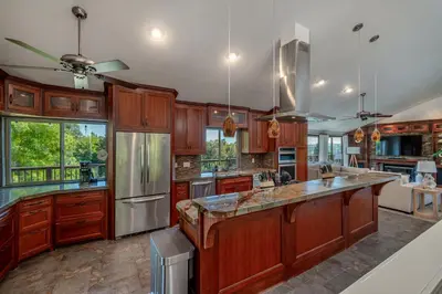 a large kitchen with wooden cabinets and stainless steel appliances at Mountain Villa in San Diego - Pool & Waterslide, Spa, Pickle Ball, Game room in La Mesa