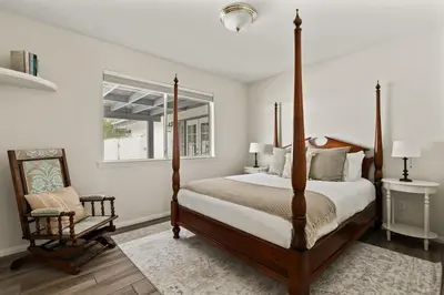a bedroom with a four poster bed and a chair at Casa Verde Wine Country Estate w Pickleball Casita in Temecula