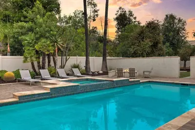 a swimming pool with lounge chairs next to a fence at Casa Verde Wine Country Estate w Pickleball Casita in Temecula