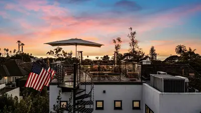a balcony with an umbrella on top of a building at European Charm Meets La Jolla Rooftop Views in San Diego