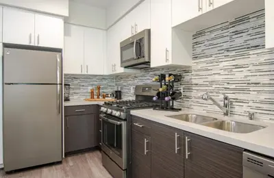 a kitchen with a stainless steel refrigerator and a sink at Vive on The Park in San Diego