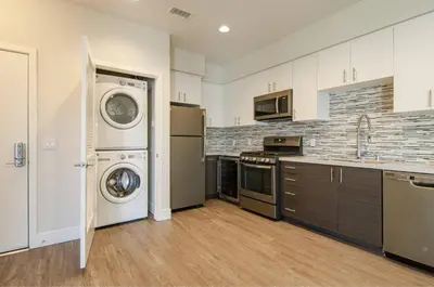 a kitchen with a washer and dryer in it at Vive on The Park in San Diego