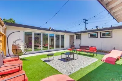a yard with a patio with red furniture and green grass at Sunny Retreat Beaches Lakes Trails in La Mesa
