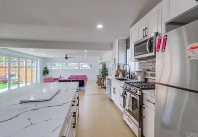 a large kitchen with white counter tops and appliances at Sunny Retreat Beaches Lakes Trails in La Mesa