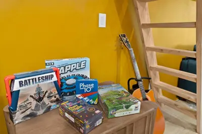 a table with games and a guitar next to a bunk bed at Sunny Loft Beaches Lakes Trails in La Mesa
