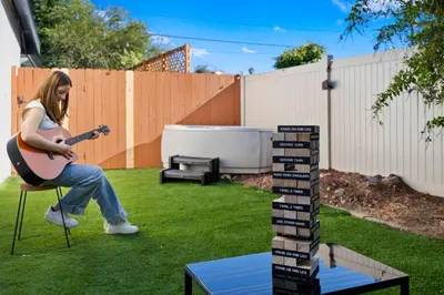 a woman sitting in a chair playing a guitar in a yard at Sunny Loft Beaches Lakes Trails in La Mesa