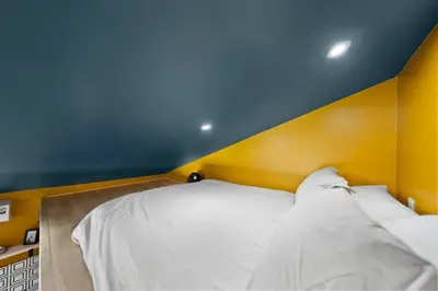 a bed in a room with a blue and yellow wall at Sunny Loft Beaches Lakes Trails in La Mesa