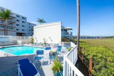 a patio with chairs and a swimming pool at #Marbella Lane - Bayfront Bliss Sunset Views & Pool in San Diego