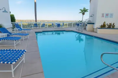 a swimming pool on a resort with blue chairs at #Marbella Lane - Bayfront Bliss Sunset Views & Pool in San Diego