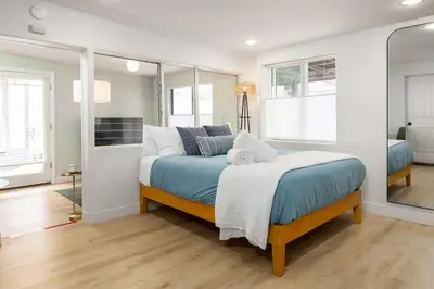 a bedroom with a bed with blue sheets and pillows at Studio In Carlsbad Village in Carlsbad