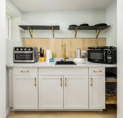 a kitchen with white cabinets and a microwave at Studio In Carlsbad Village in Carlsbad