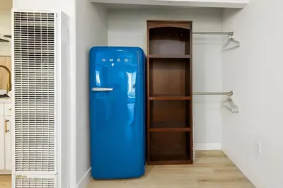 a blue refrigerator in a room with a shelf at Studio In Carlsbad Village in Carlsbad