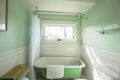 a white bathroom with a tub and a window at Gorgeous Eccentric Family Home with Cowboy Pool in San Diego