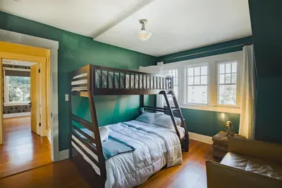 a bedroom with a bunk bed and green walls at Gorgeous Eccentric Family Home with Cowboy Pool in San Diego