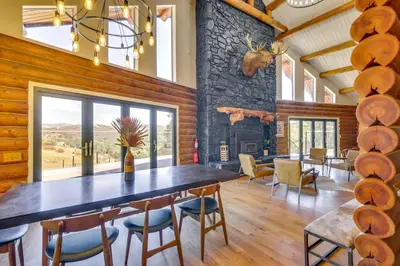 a dining room with a large wooden table and chairs at Red Hawk Ridge SD Mag Design Winner in Alpine