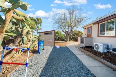 a backyard with a house and a tree at Westinghouse Park Retreat Decks, BBQ, Fire Pits in San Diego