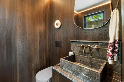 a bathroom with wood paneling and a sink and a mirror at Solana Beach Luxury with Panoramic Ocean Views in Solana Beach
