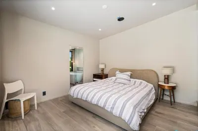 a white bedroom with a bed and a chair at Solana Beach Luxury with Panoramic Ocean Views in Solana Beach