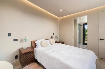 a bedroom with a large white bed with a night stand at Solana Beach Luxury with Panoramic Ocean Views in Solana Beach