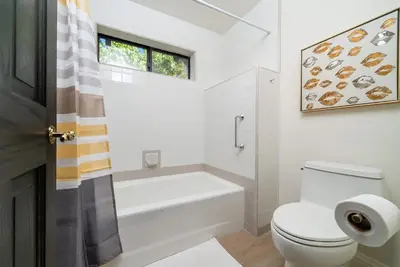 a bathroom with a toilet and a tub and a window at Fallbrook Hilltop Sanctuary - Pool & Pickleball in Fallbrook
