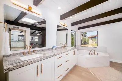 a white bathroom with two sinks and a tub and a tubermott at Fallbrook Hilltop Sanctuary - Pool & Pickleball in Fallbrook