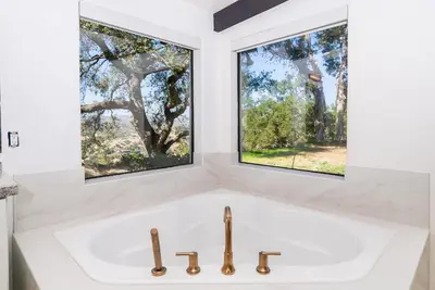 a white sink in a bathroom with two windows at Fallbrook Hilltop Sanctuary - Pool & Pickleball in Fallbrook