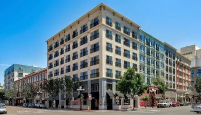 a large white building on a city street at Allura Gaslamp Condo - Office Pool Gym & Parking in San Diego