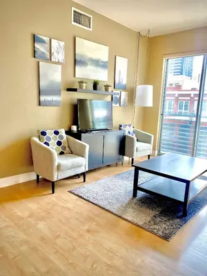 a living room with a tv and a table and chairs at Allura Gaslamp Condo - Office Pool Gym & Parking in San Diego