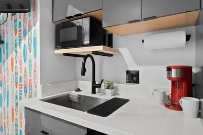 a kitchen with a sink and a coffee maker at The Neon Elm Hotel in San Diego