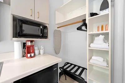 a small kitchen with a counter and a microwave at The Neon Elm Hotel in San Diego