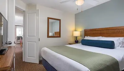 a bedroom with a large bed and a mirror at Wyndham Oceanside Pier 2BR Apartment with Resort Access in Oceanside