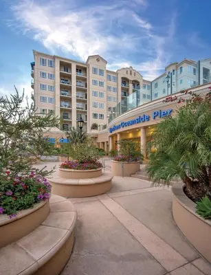 a large building with plants in front of it at Wyndham Oceanside Pier 2BR Apartment with Resort Access in Oceanside