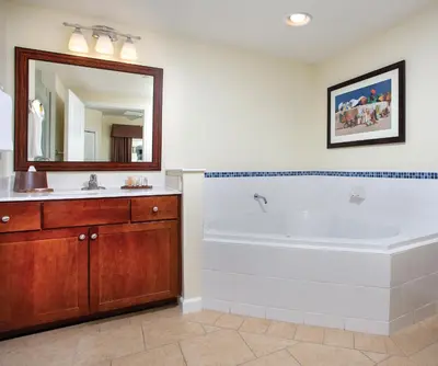 a bathroom with a tub and a sink and a mirror at Wyndham Oceanside Pier 2BR Apartment with Resort Access in Oceanside