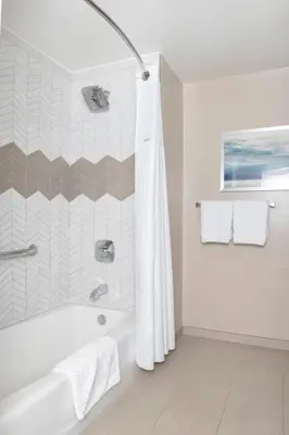 a white bathroom with a tub and a shower at Wyndham Harbour Lights Studio Apartment with Resort Access in San Diego