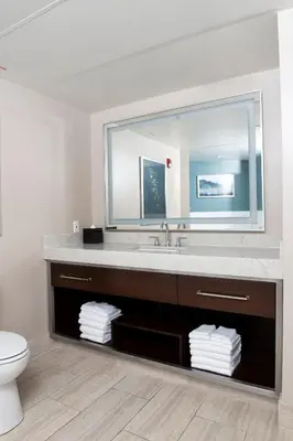 a bathroom with a sink and a toilet and a mirror at Wyndham Harbour Lights Studio Apartment with Resort Access in San Diego