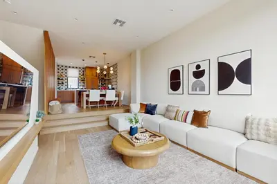 a living room with a white couch and a table at Sea & Stroll Abode in Carlsbad