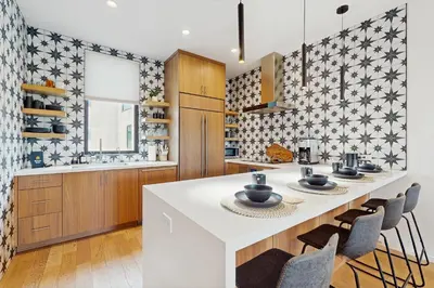 a kitchen with a large white island with chairs at Sea & Stroll Abode in Carlsbad