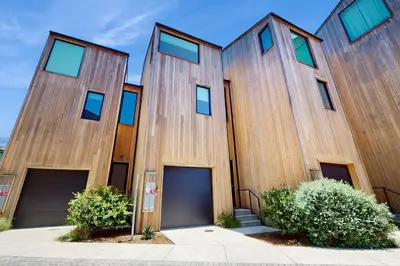 a wooden building with four garage doors in front at Sea & Stroll Abode in Carlsbad