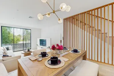 a living room with a table and chairs and a staircase at Sea & Stroll Abode in Carlsbad