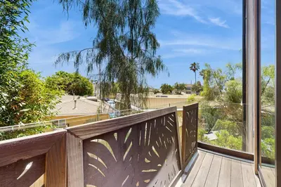 a balcony with a view of a yard at Sea & Stroll Abode in Carlsbad
