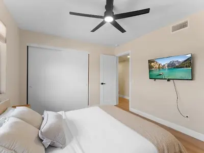 a bedroom with a bed and a flat screen tv on the wall at Sunset house in El Cajon