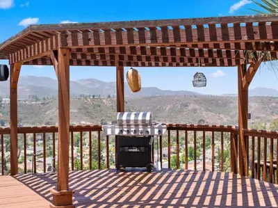 a wooden gazebo with a chair and a grill on a deck at Sunset house in El Cajon