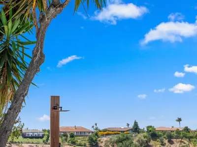 a wooden sign next to a palm tree at Sunset house in El Cajon