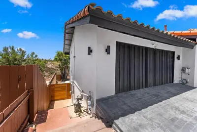 a small white house with a black garage at Sunset house in El Cajon