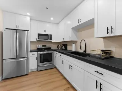 a kitchen with white cabinets and stainless steel appliances at Sunset house in El Cajon